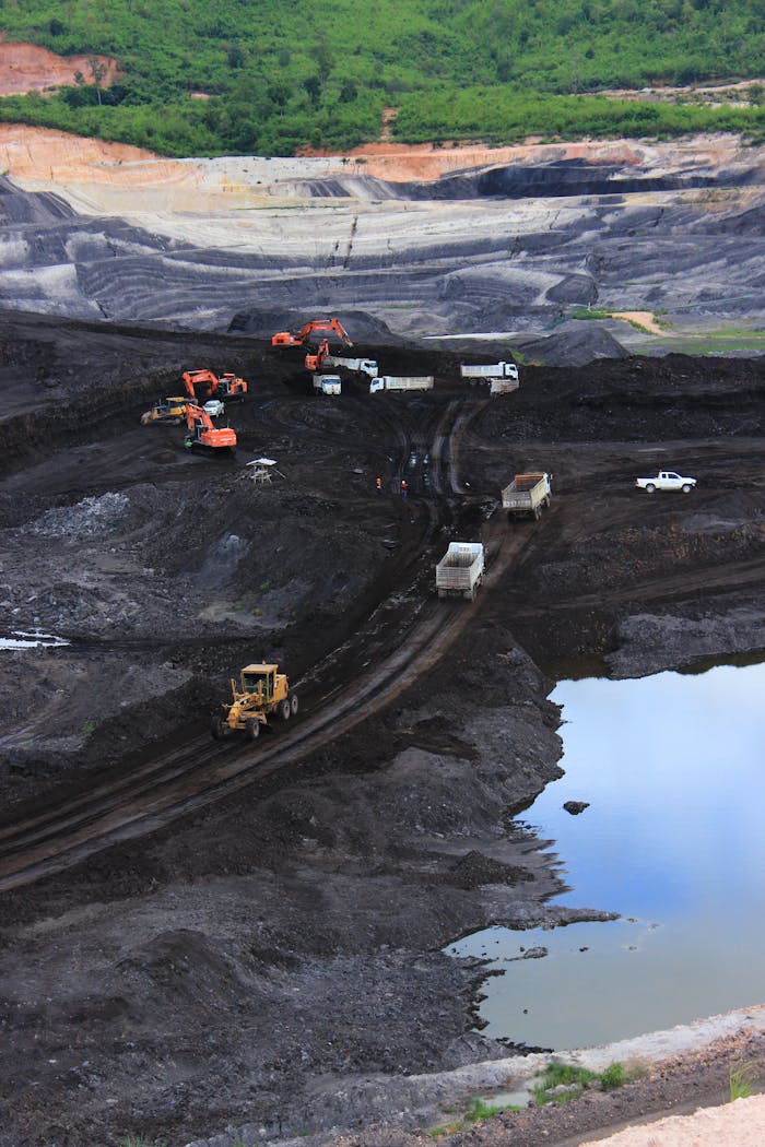 Aerial photograph showcasing machinery working in a vast open-pit mining site.